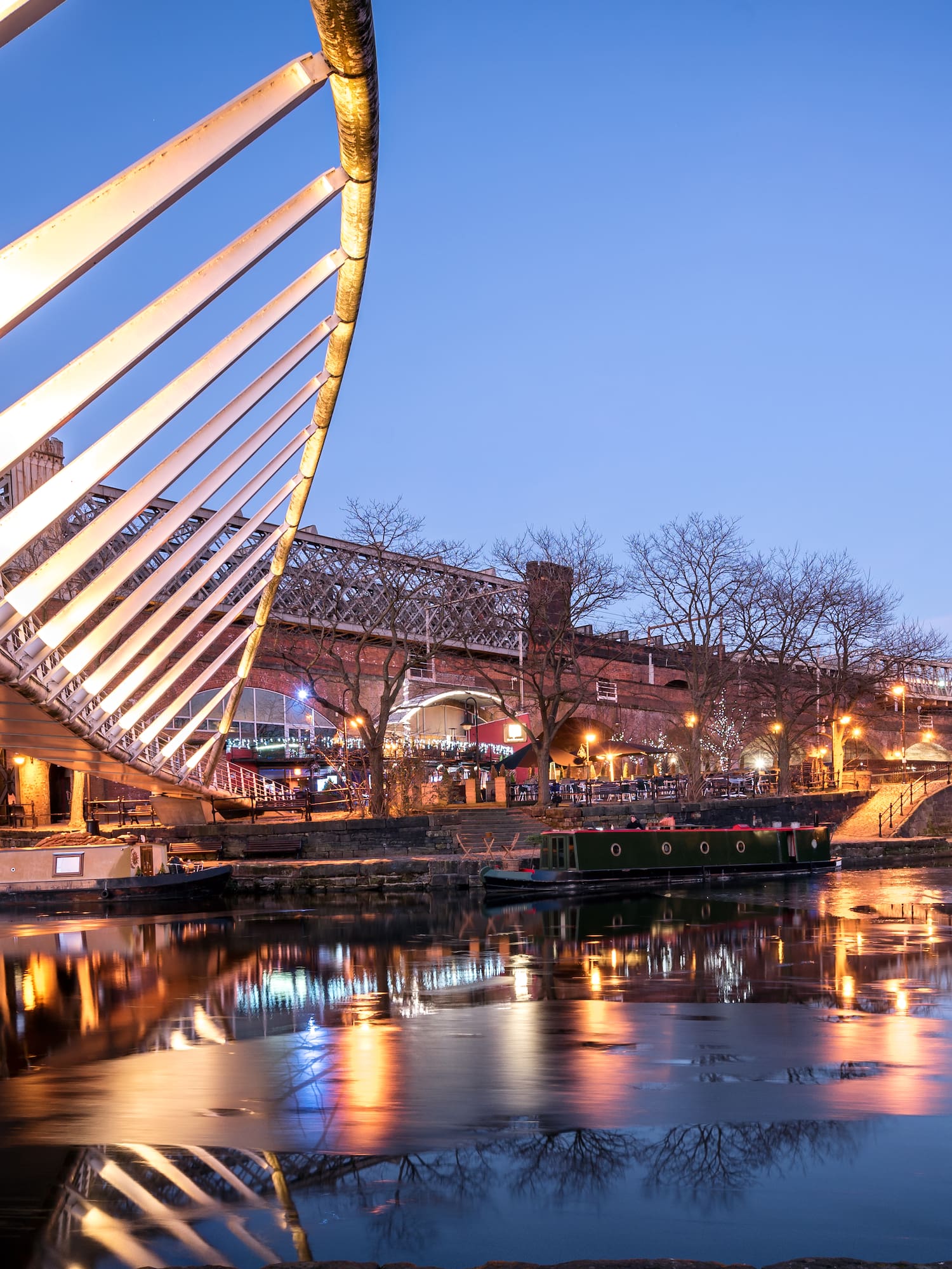 a bridge over water with buildings and a bridge in the background