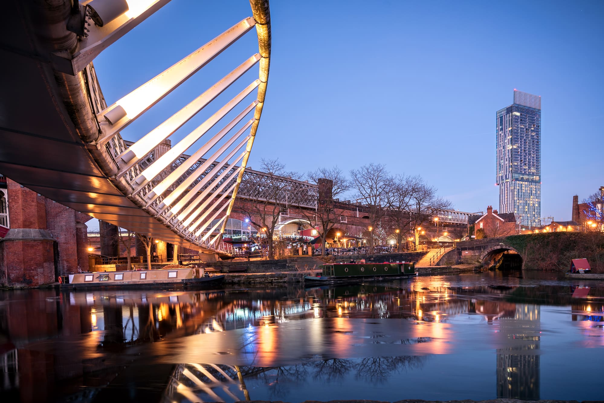 a bridge over water with buildings and a bridge in the background
