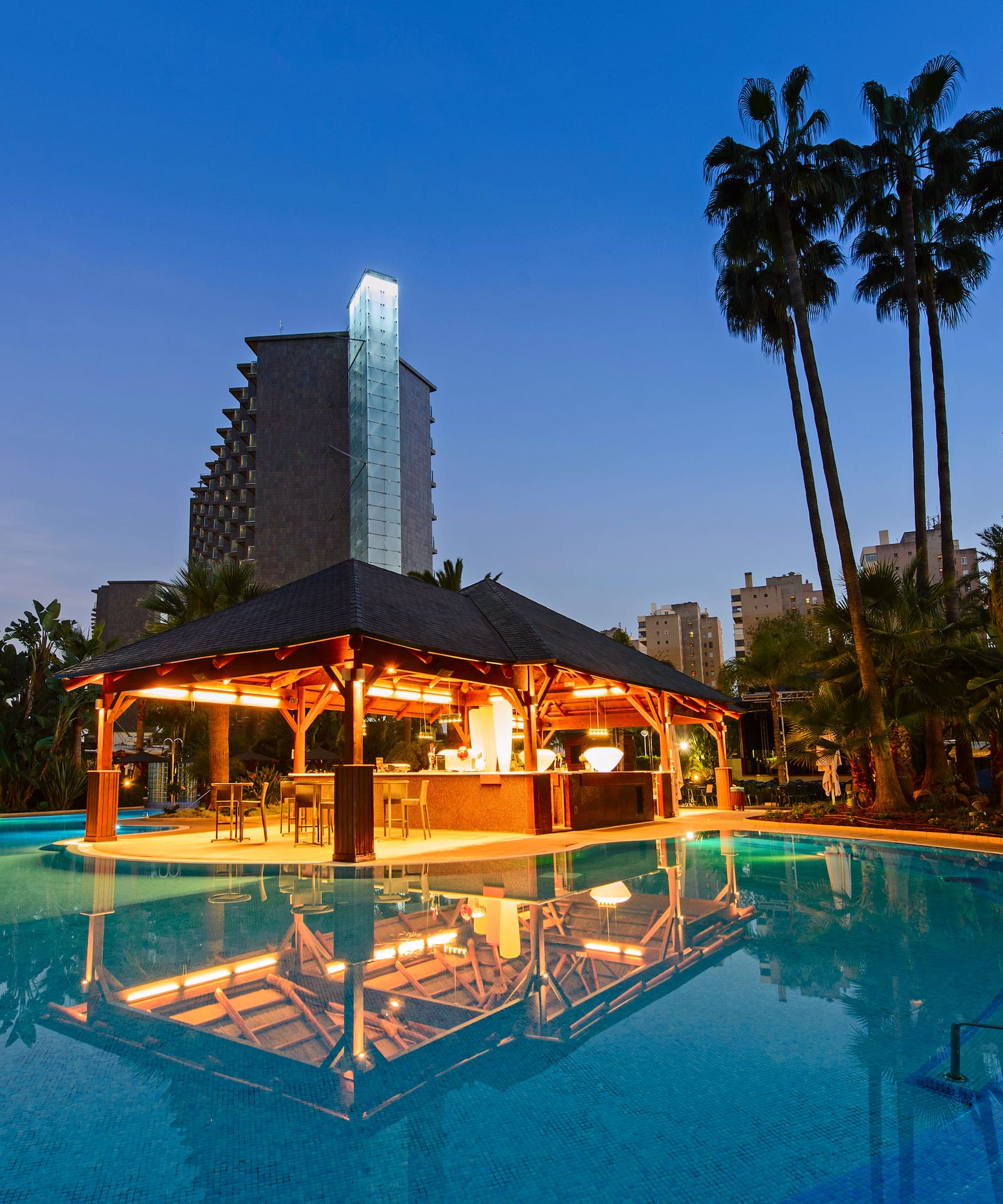 a pool with a gazebo and palm trees