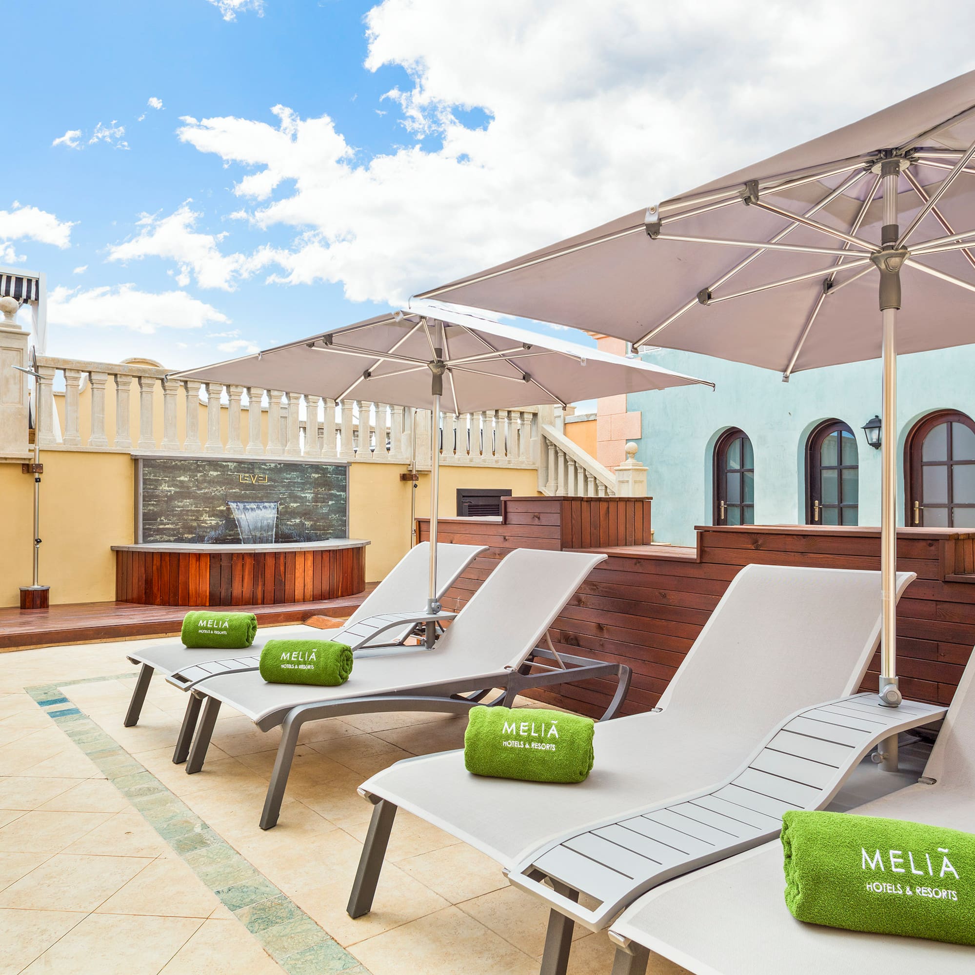 a group of chairs and umbrellas on a rooftop