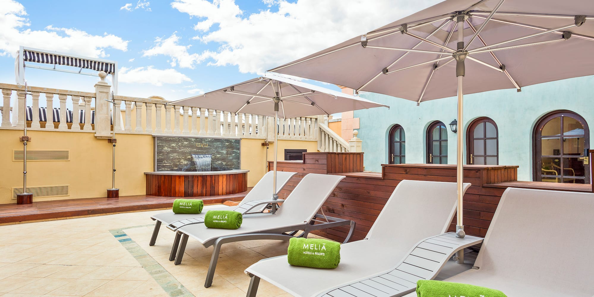 a group of chairs and umbrellas on a rooftop