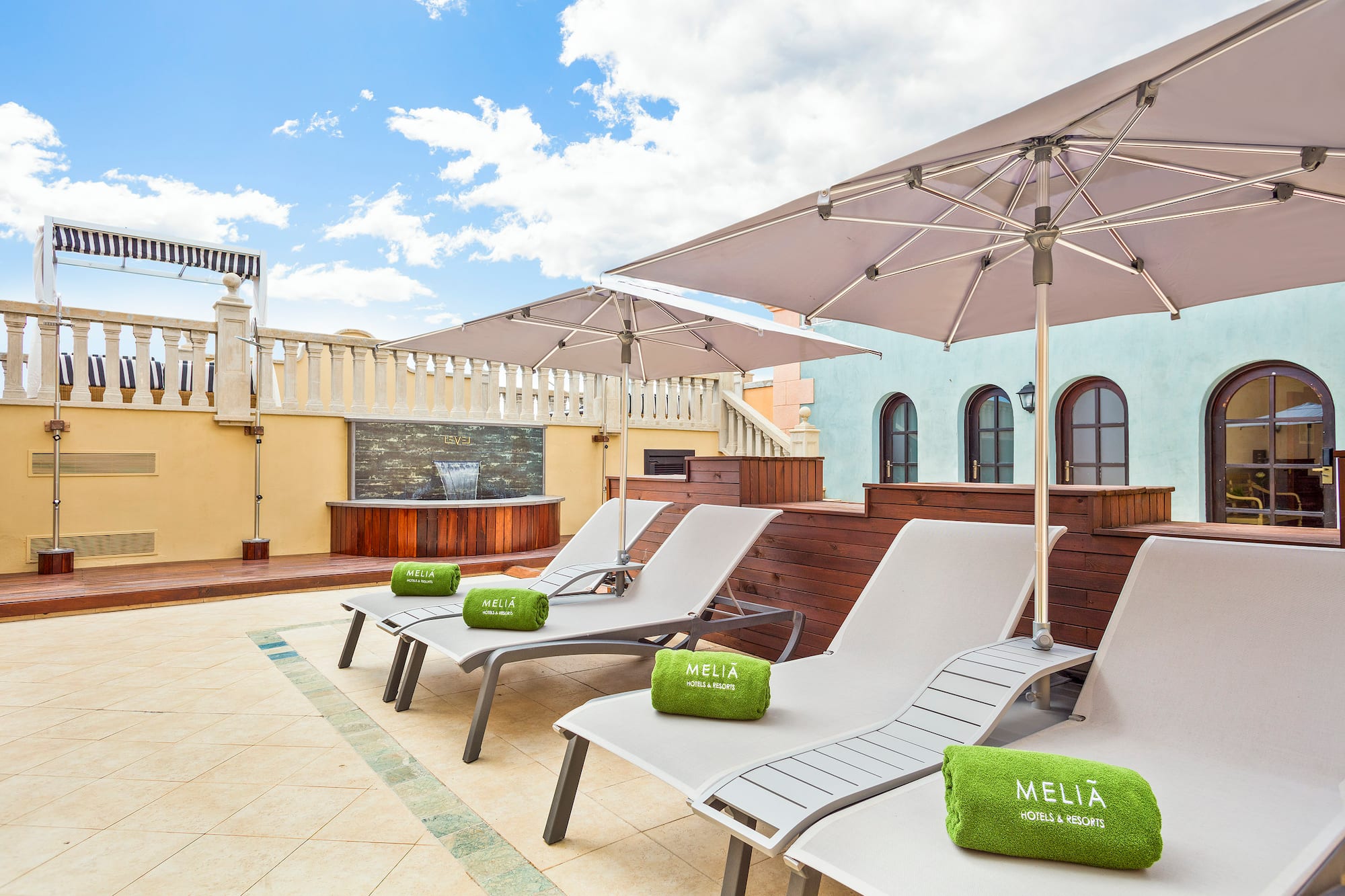 a group of chairs and umbrellas on a rooftop