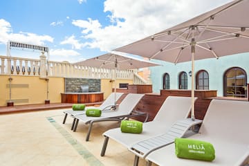 a group of chairs and umbrellas on a rooftop