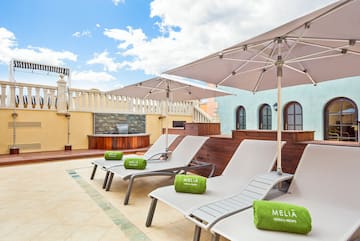 a group of chairs and umbrellas on a rooftop