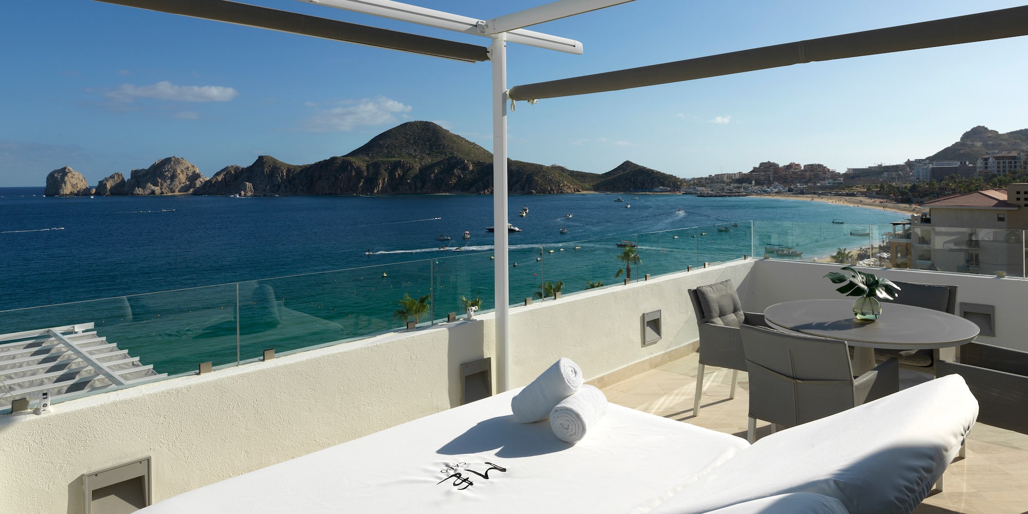a table and chairs on a balcony overlooking a body of water