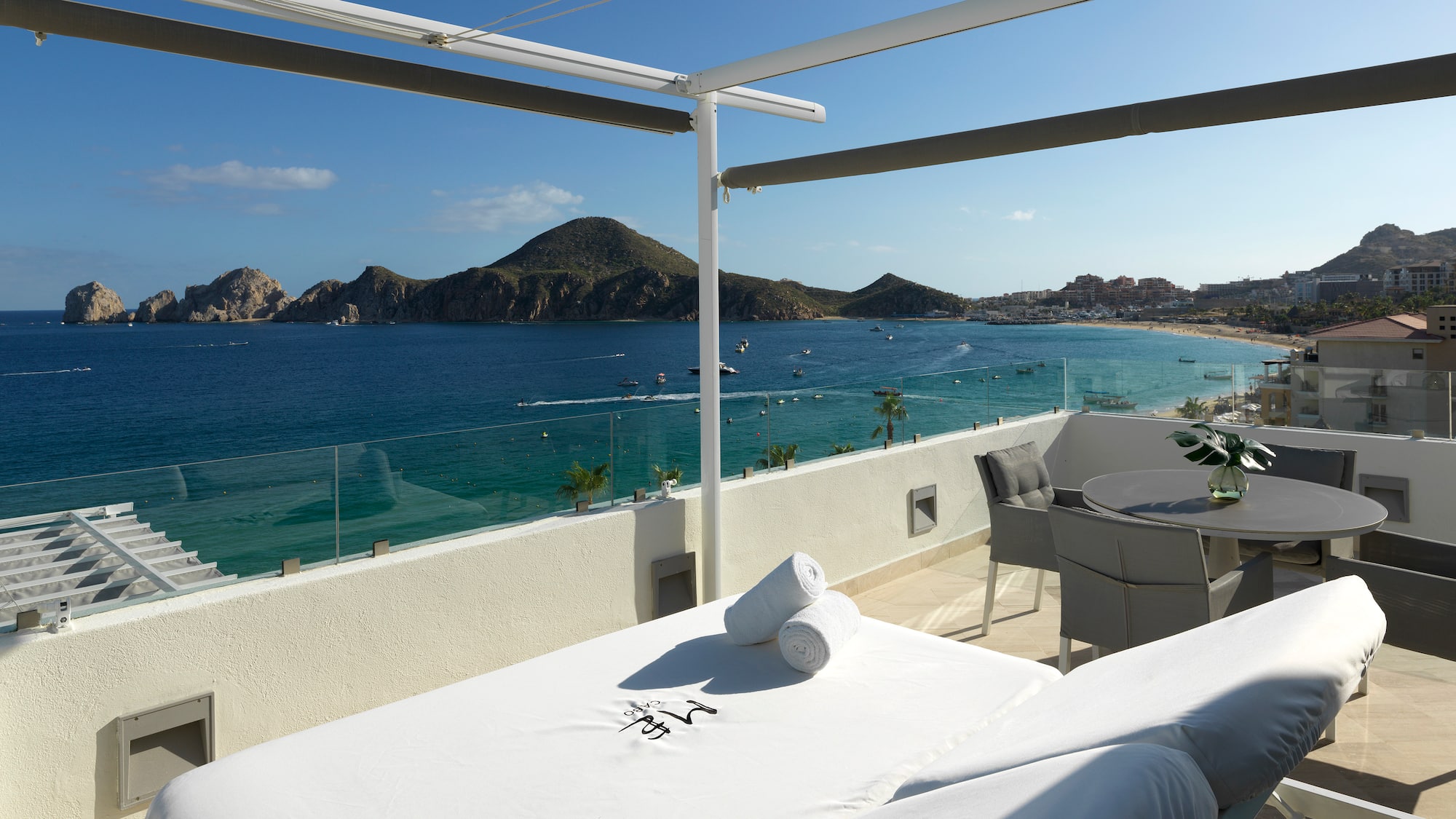 a table and chairs on a balcony overlooking a body of water