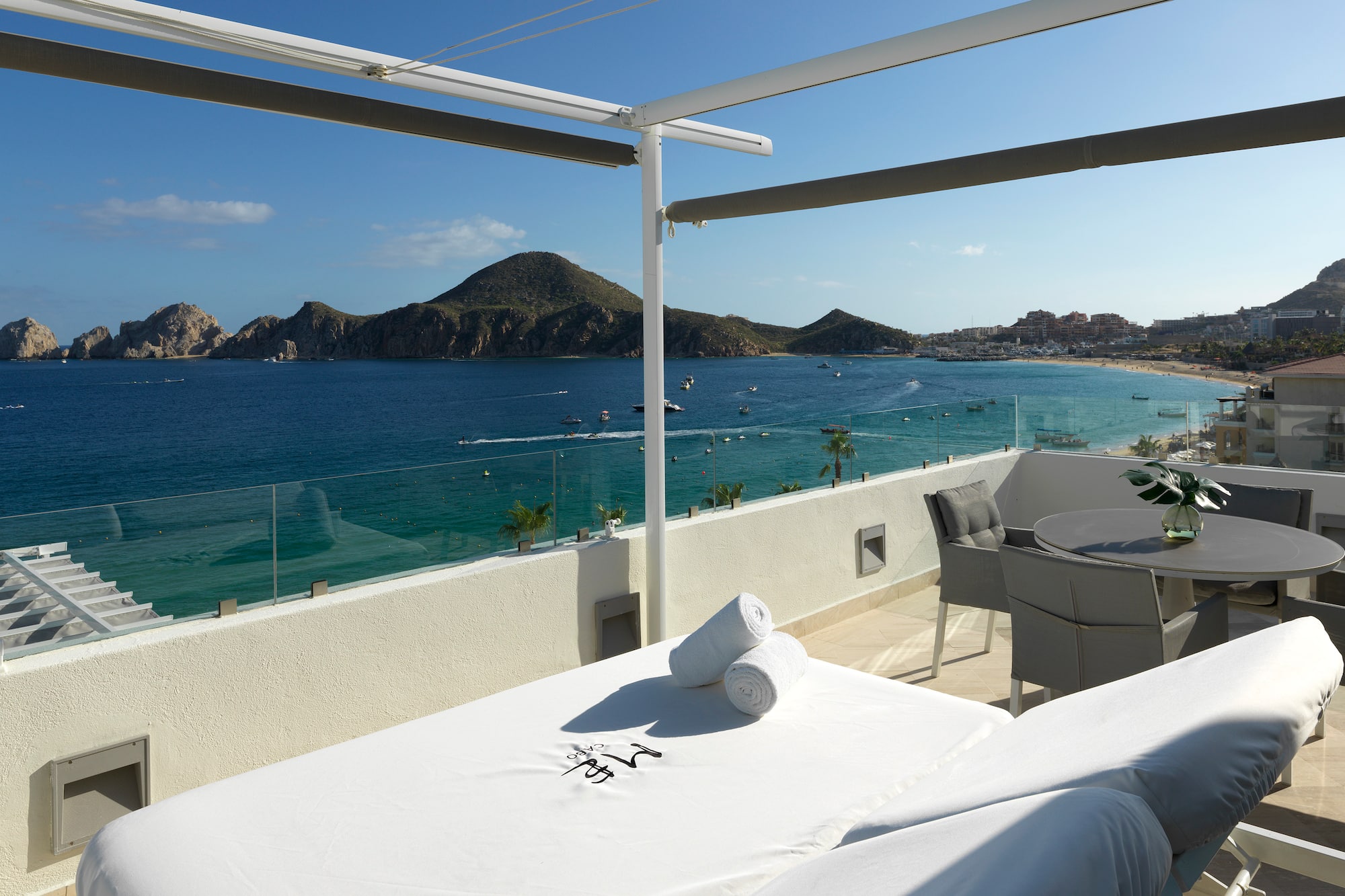 a table and chairs on a balcony overlooking a body of water