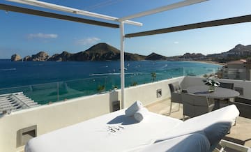 a table and chairs on a balcony overlooking a body of water