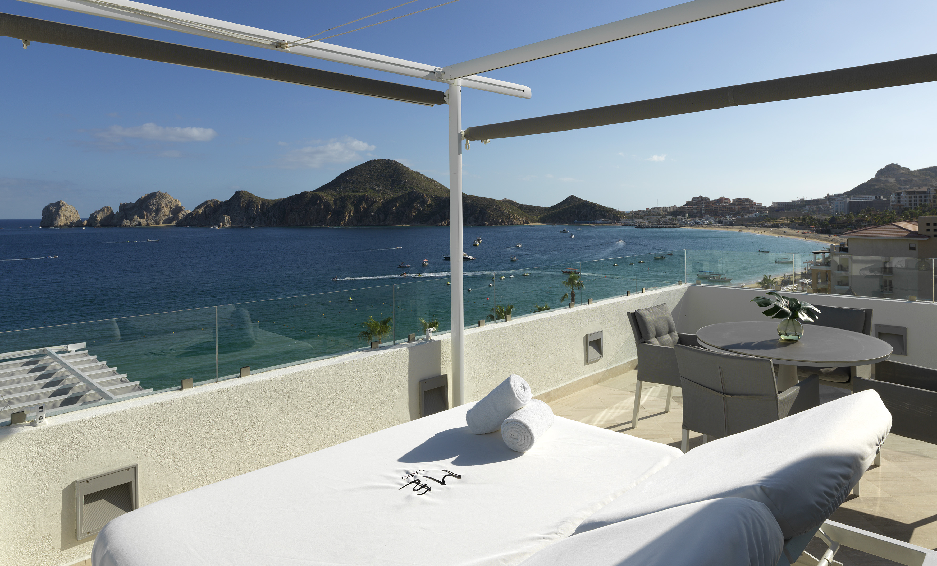 a table and chairs on a balcony overlooking a body of water