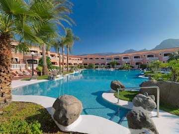 a pool with palm trees and a building
