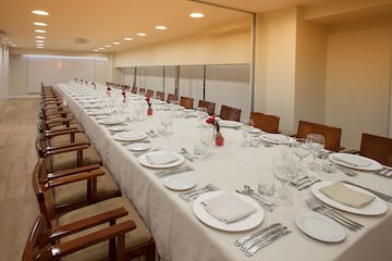 a long table with white tablecloths and plates