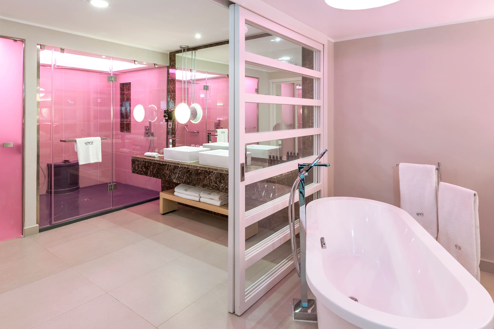 a bathroom with pink walls and a tub