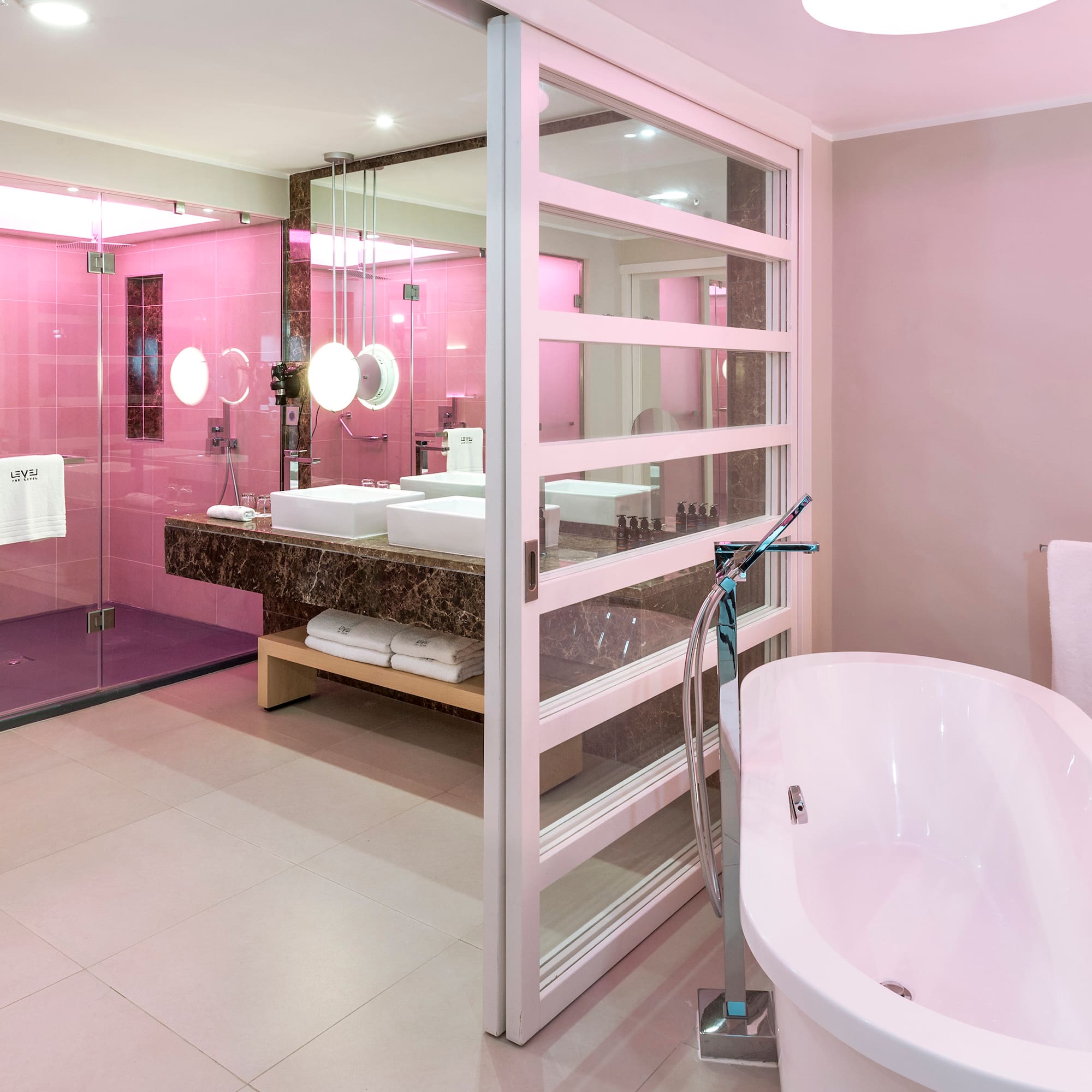 a bathroom with pink walls and a tub