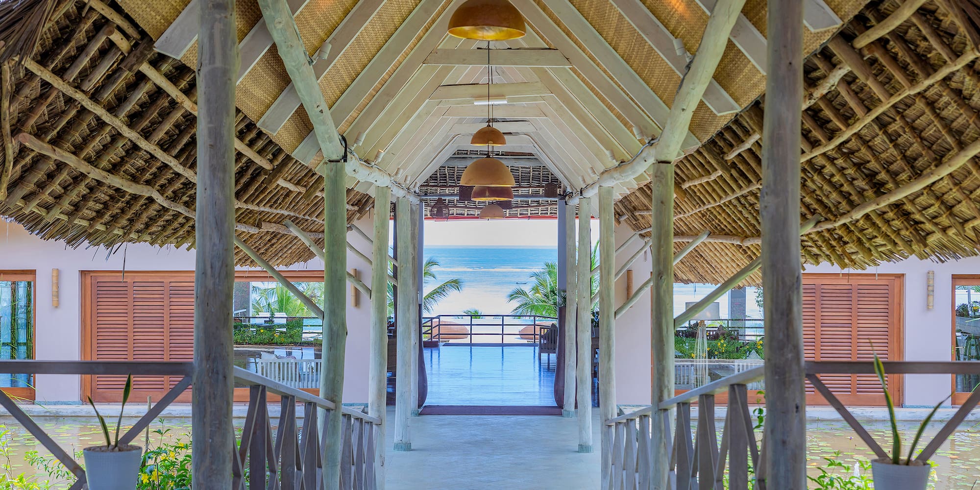 a walkway with a roof and a beach view