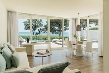 a living room with a table and chairs and a table with chairs and a table with a view of the ocean