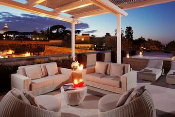 a patio with a hot tub and furniture