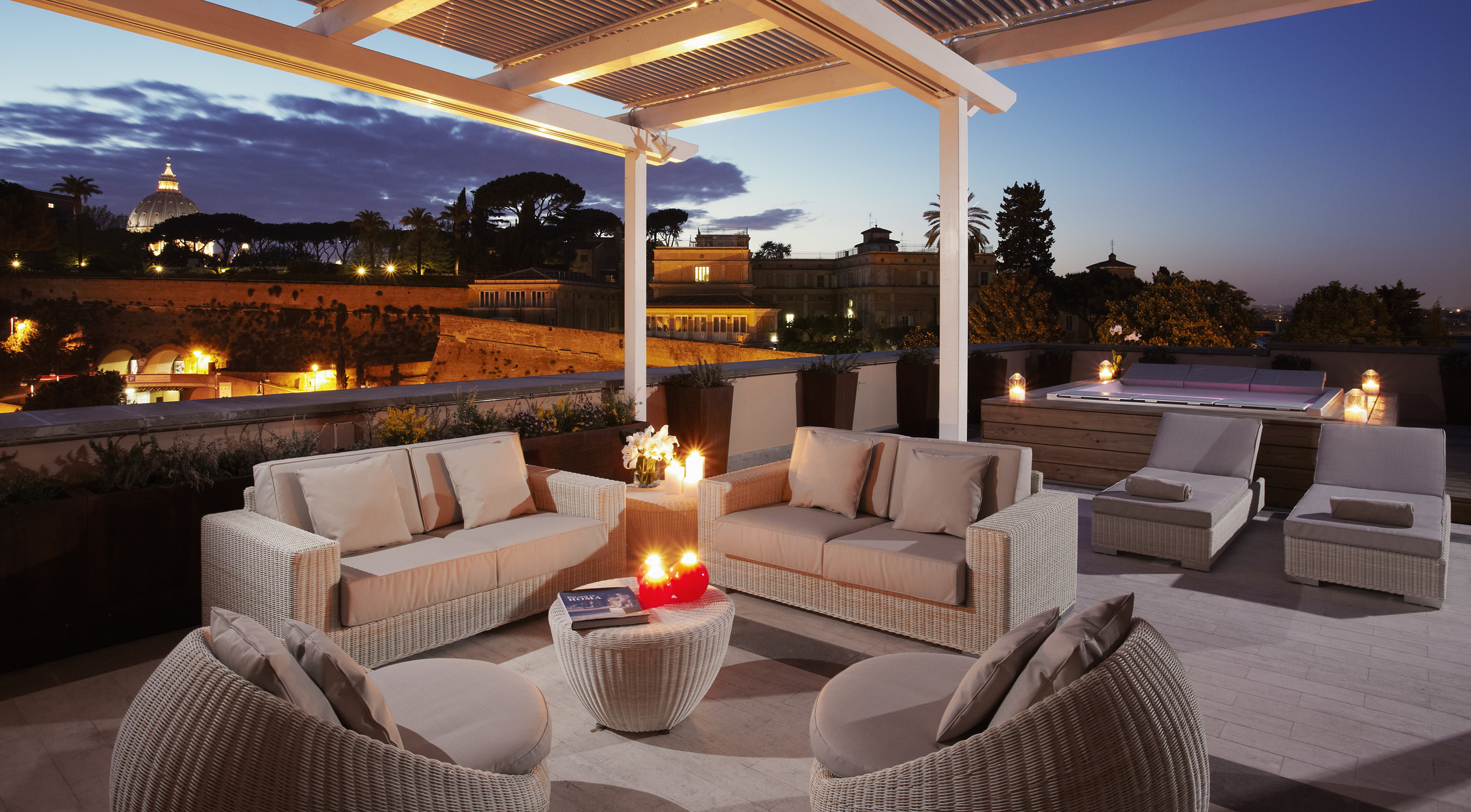Luxury Rome rooftop terrace at dusk with St. Peter's Basilica and hot tub.