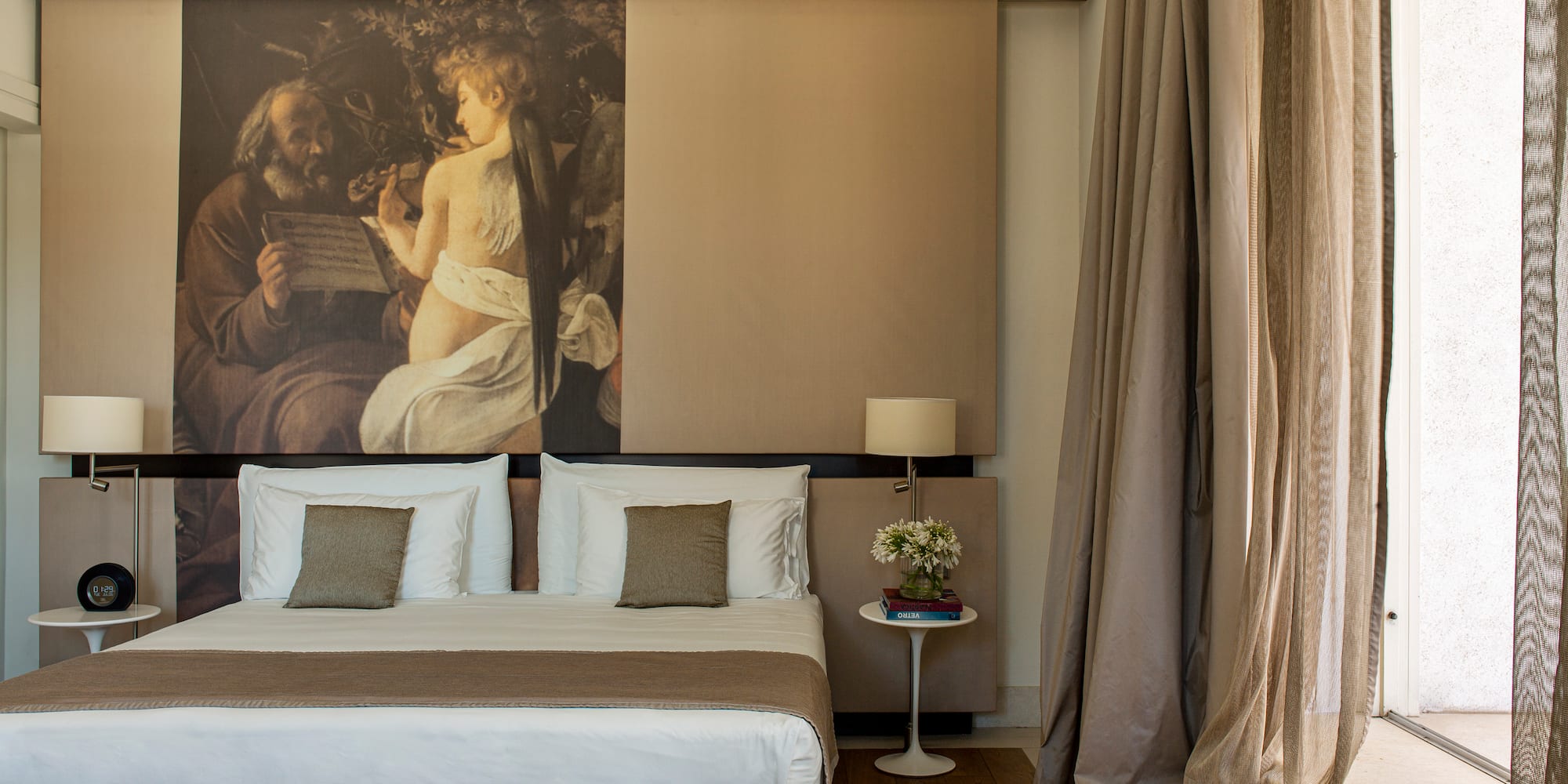 a bed with a large painting above it