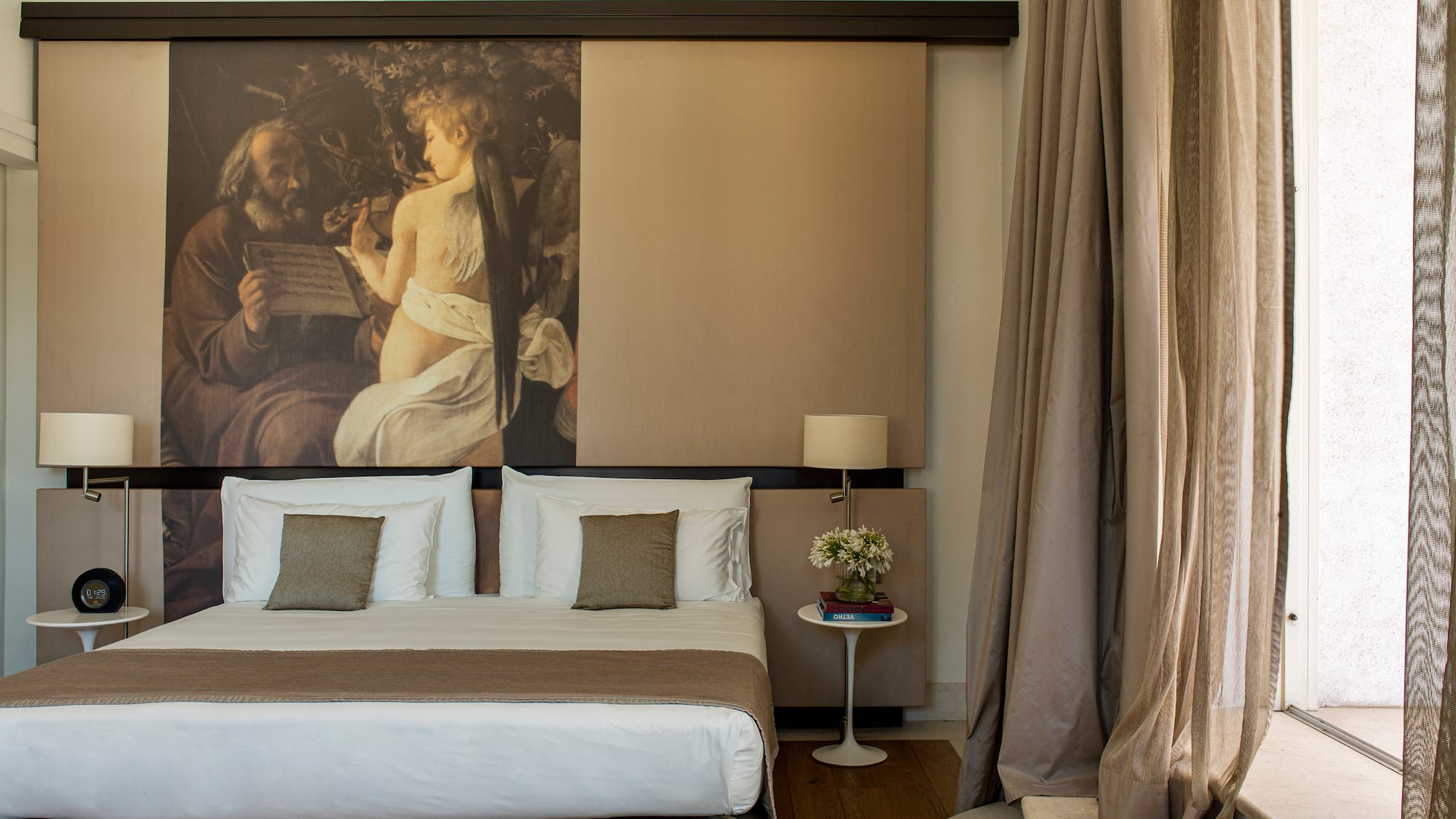 a bed with a large painting above it