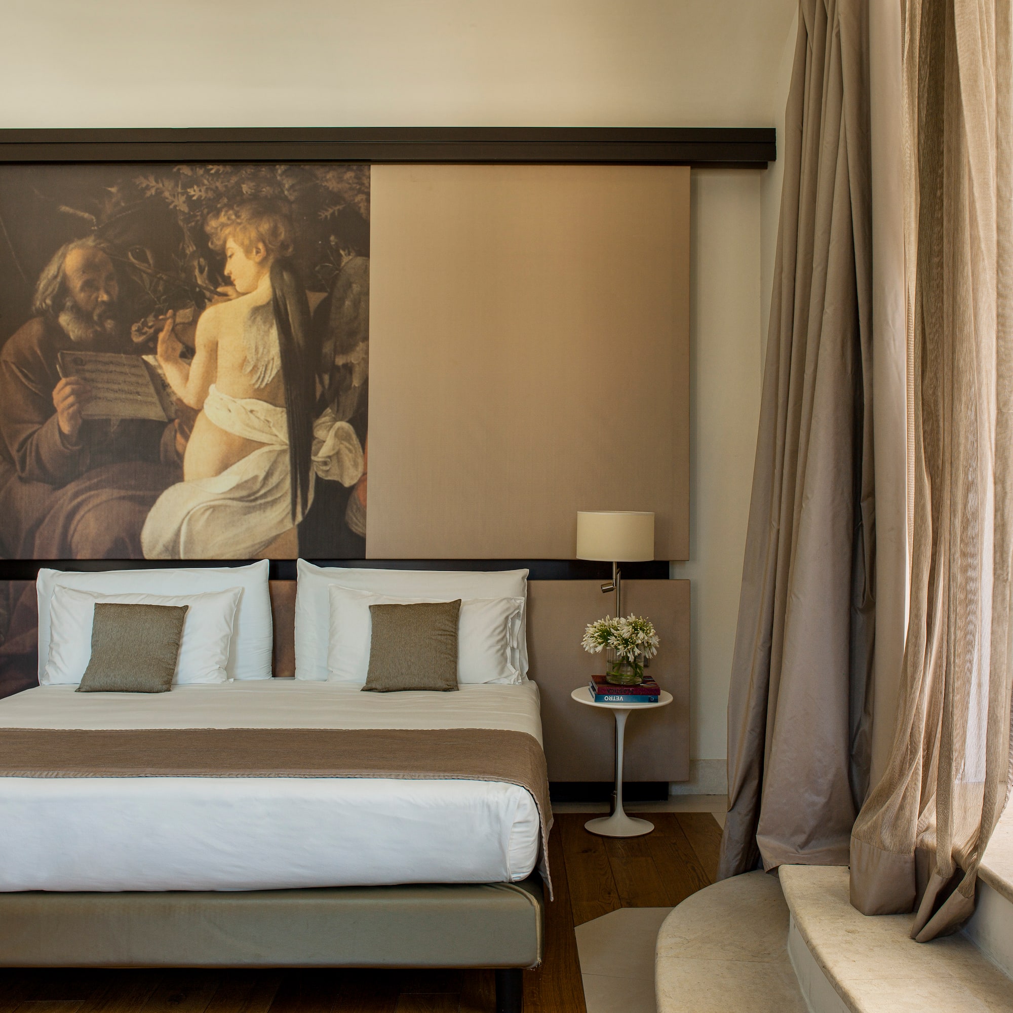 a bed with a large painting above it