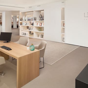 a room with a computer desk and a white wall