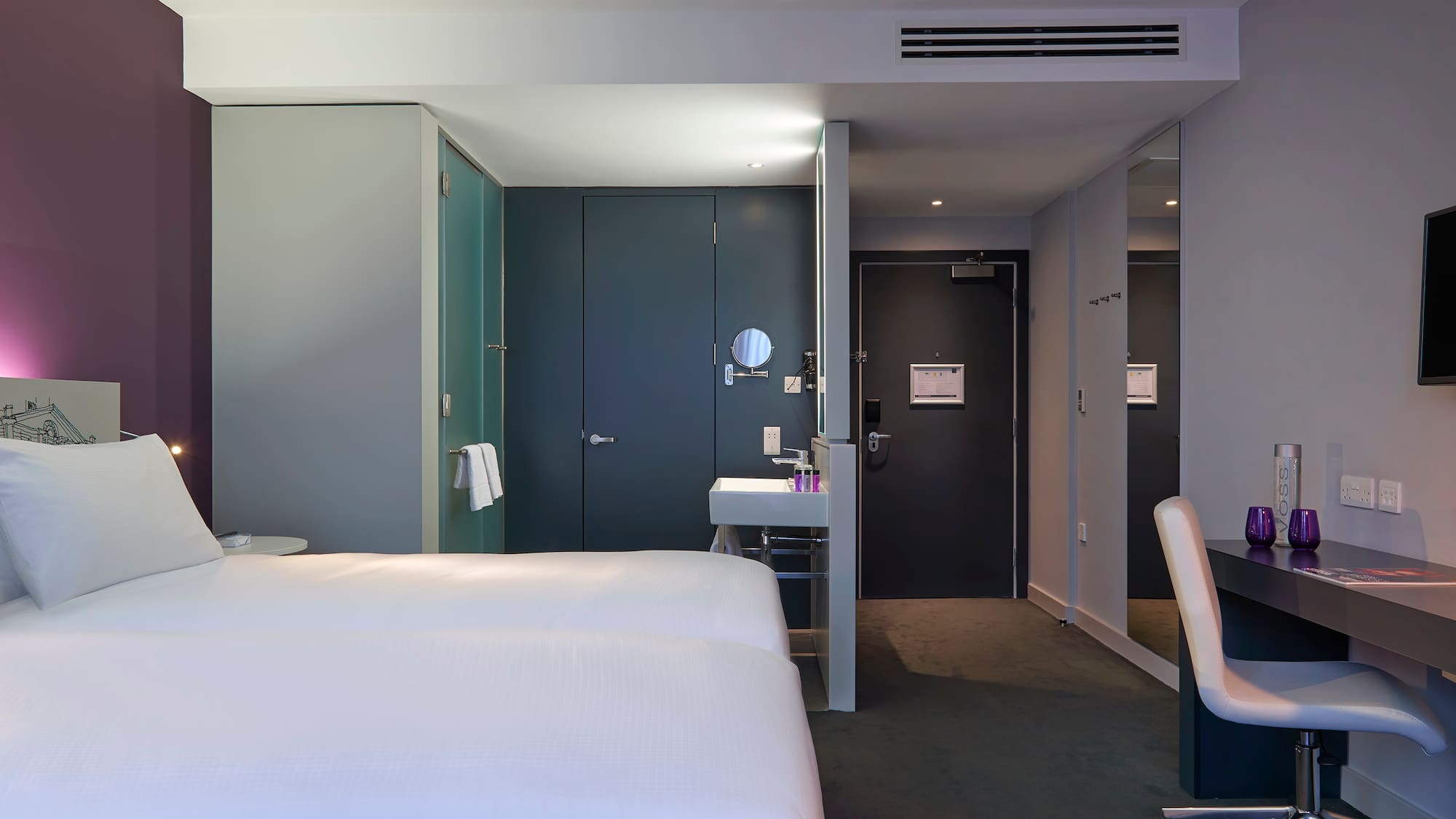 a room with two beds and a sink