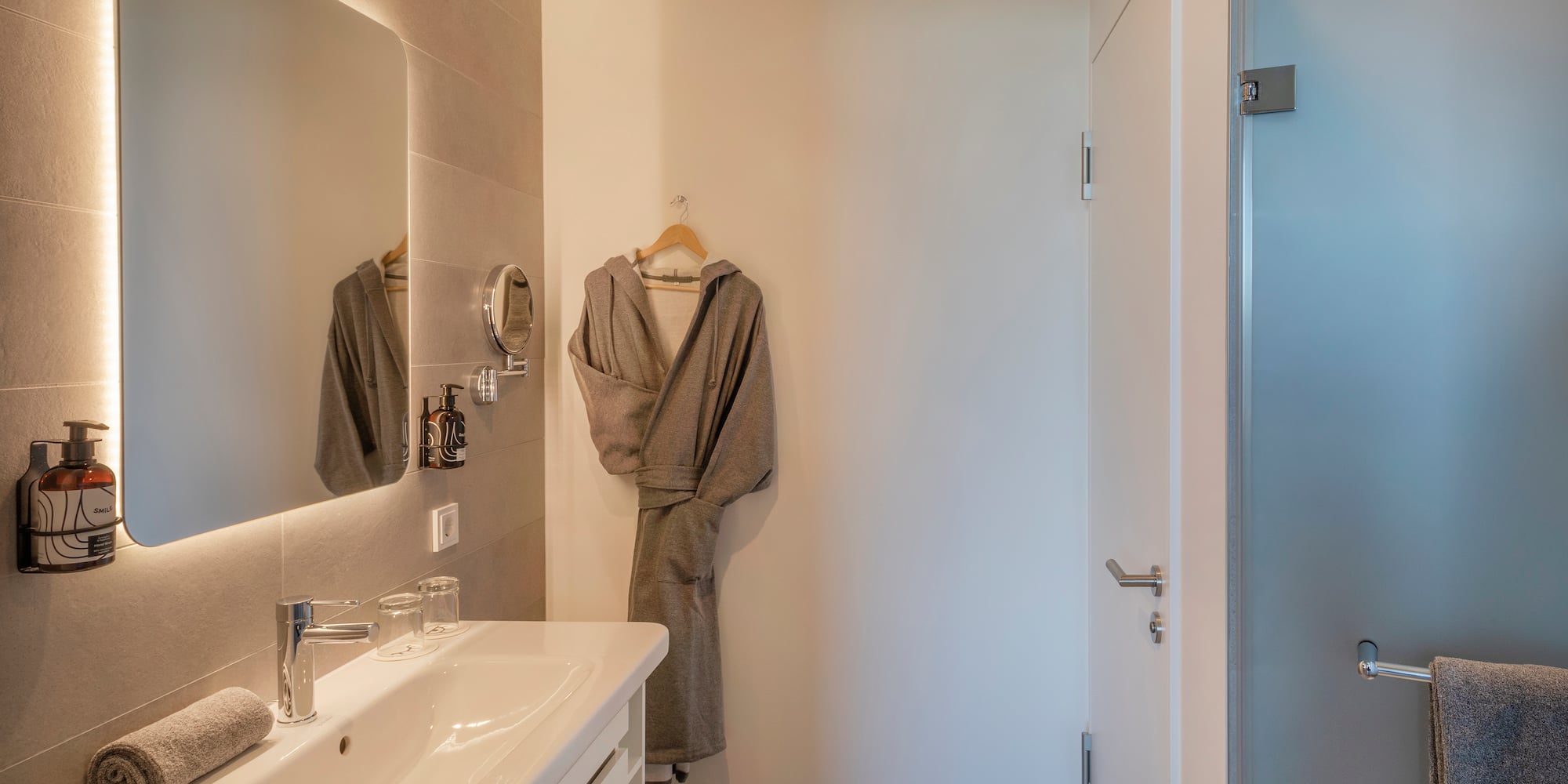 a bathroom with a bathrobe and sink