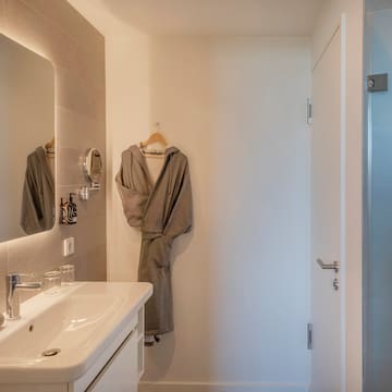 a bathroom with a bathrobe and sink