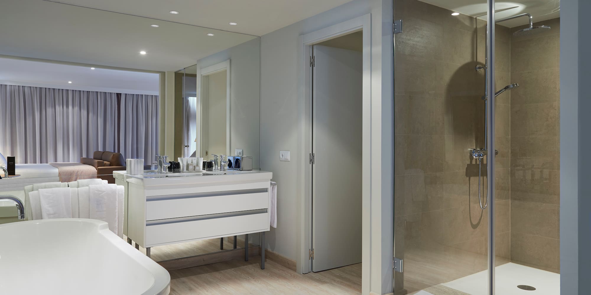a bathroom with a glass shower and a tub