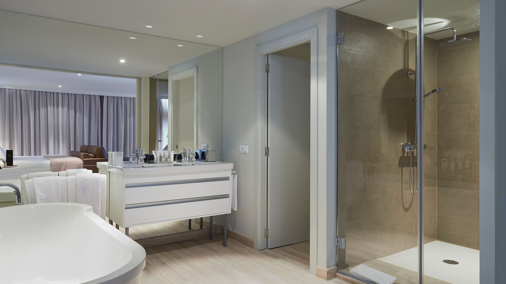 a bathroom with a glass shower and a tub