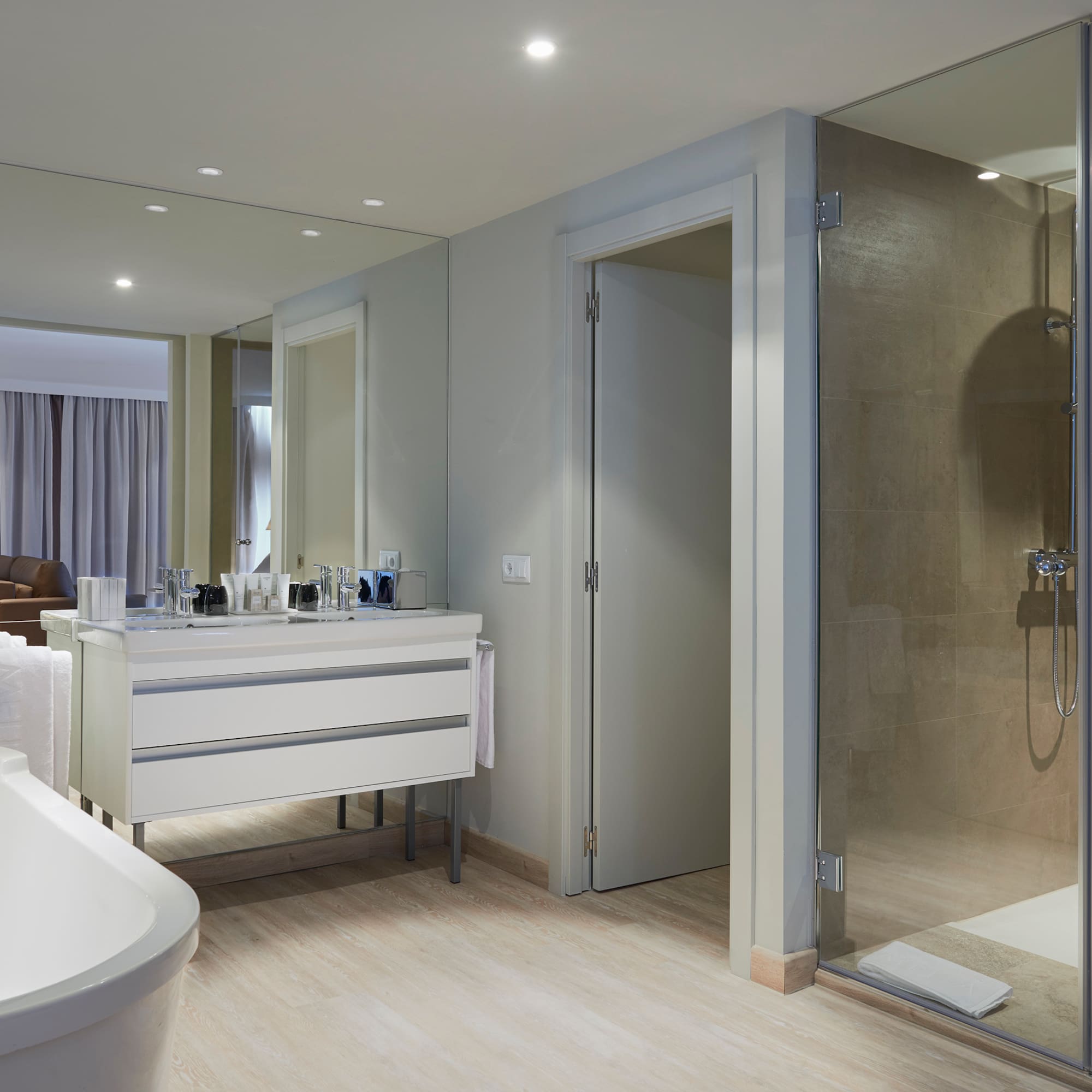 a bathroom with a glass shower and a tub