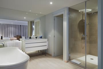 a bathroom with a glass shower and a tub