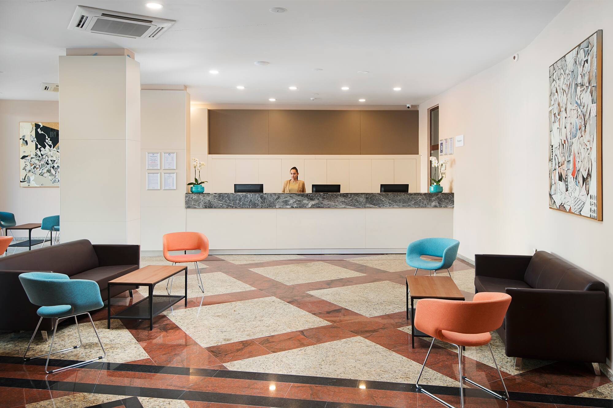 a woman standing behind a counter in a hotel lobby