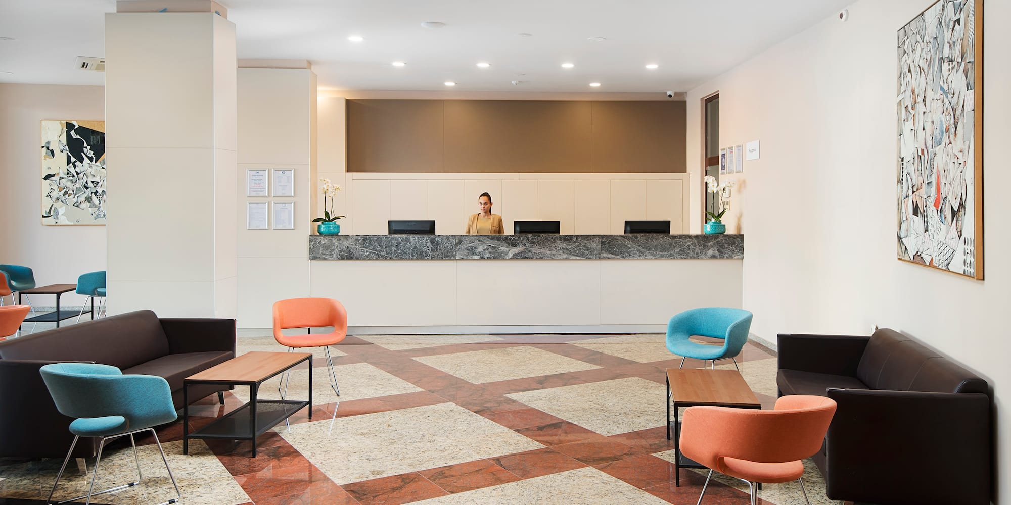 a woman standing behind a counter in a hotel lobby
