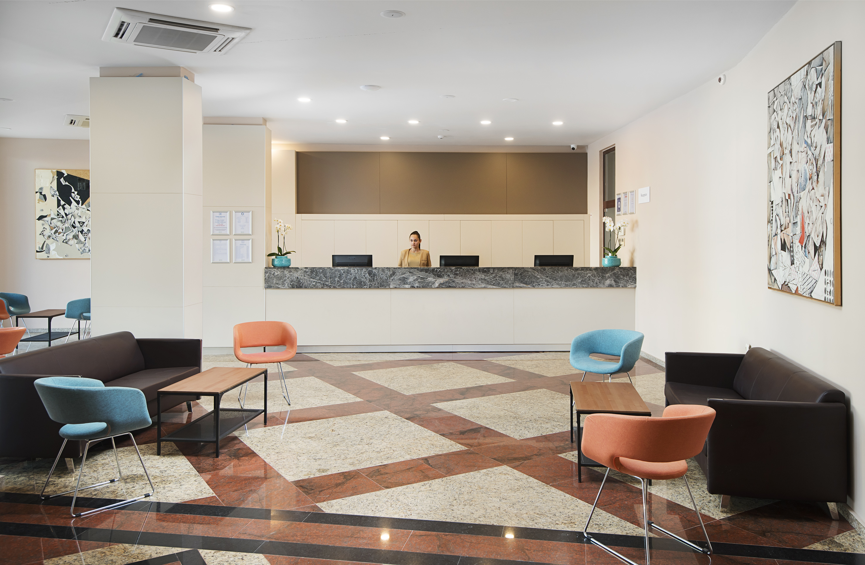 a woman standing behind a counter in a hotel lobby