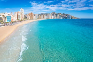 a beach with buildings and blue water
