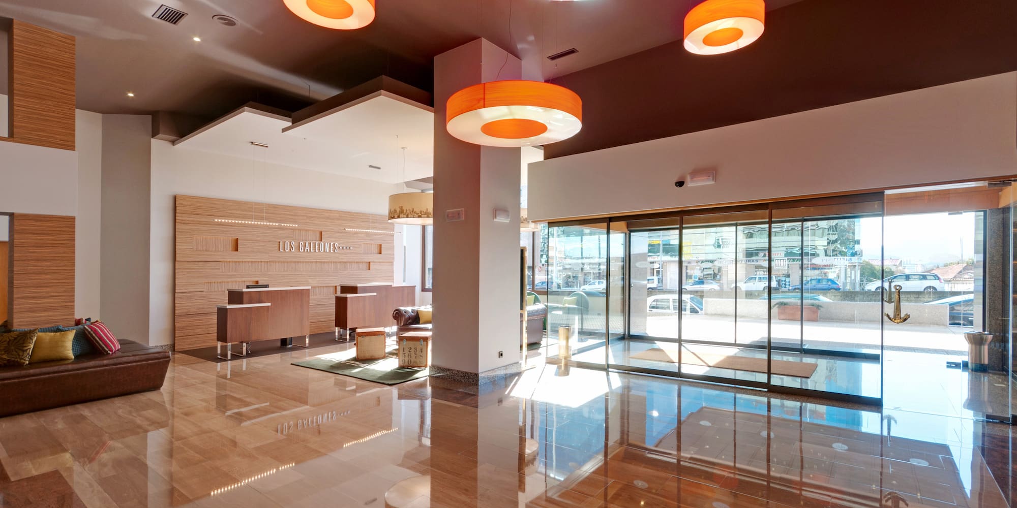 a lobby with a glass door and orange lights