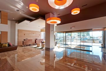 a lobby with a glass door and orange lights