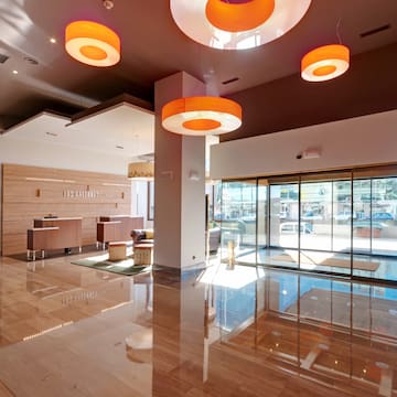 a lobby with a glass door and orange lights