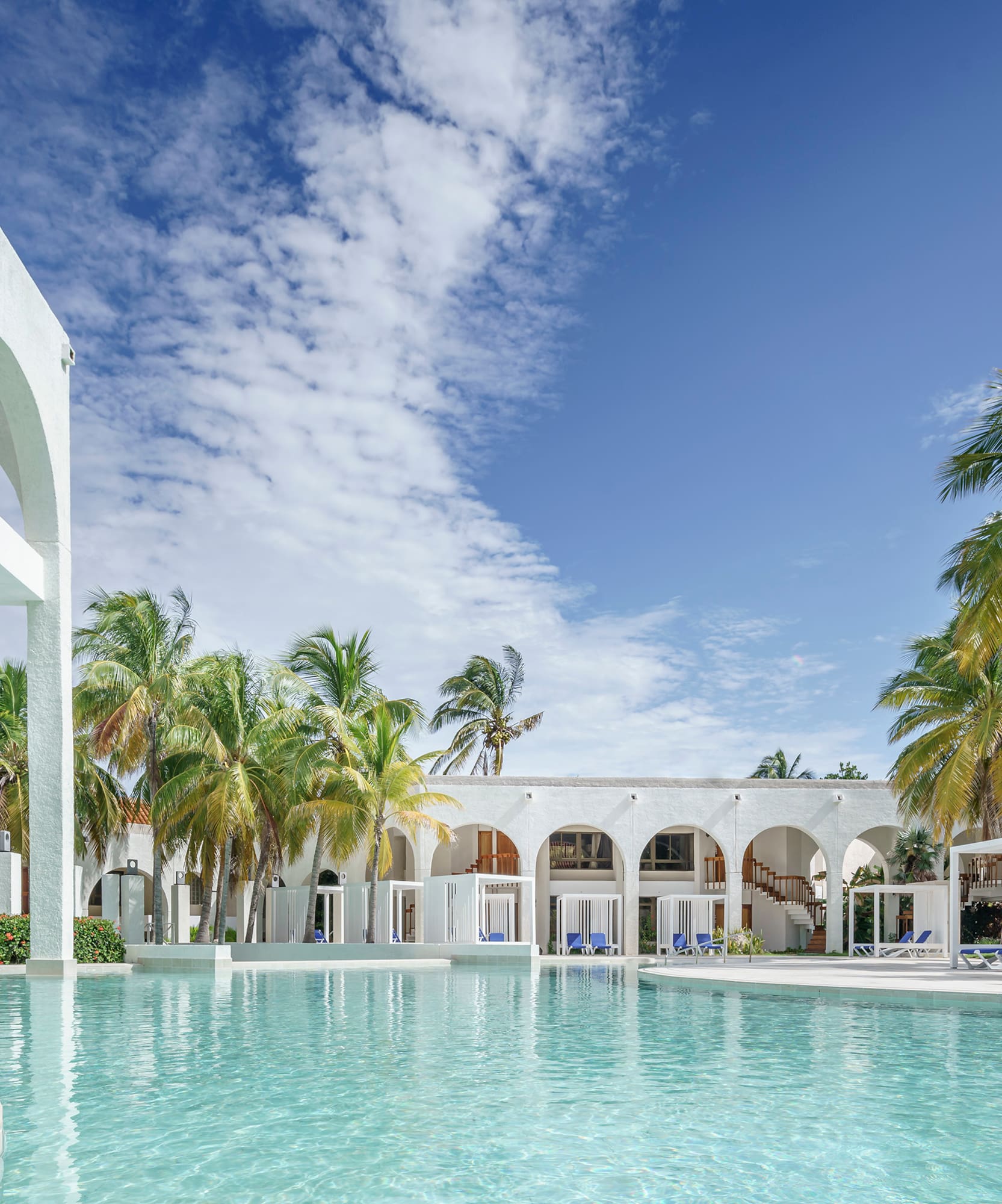 a pool with palm trees and arches
