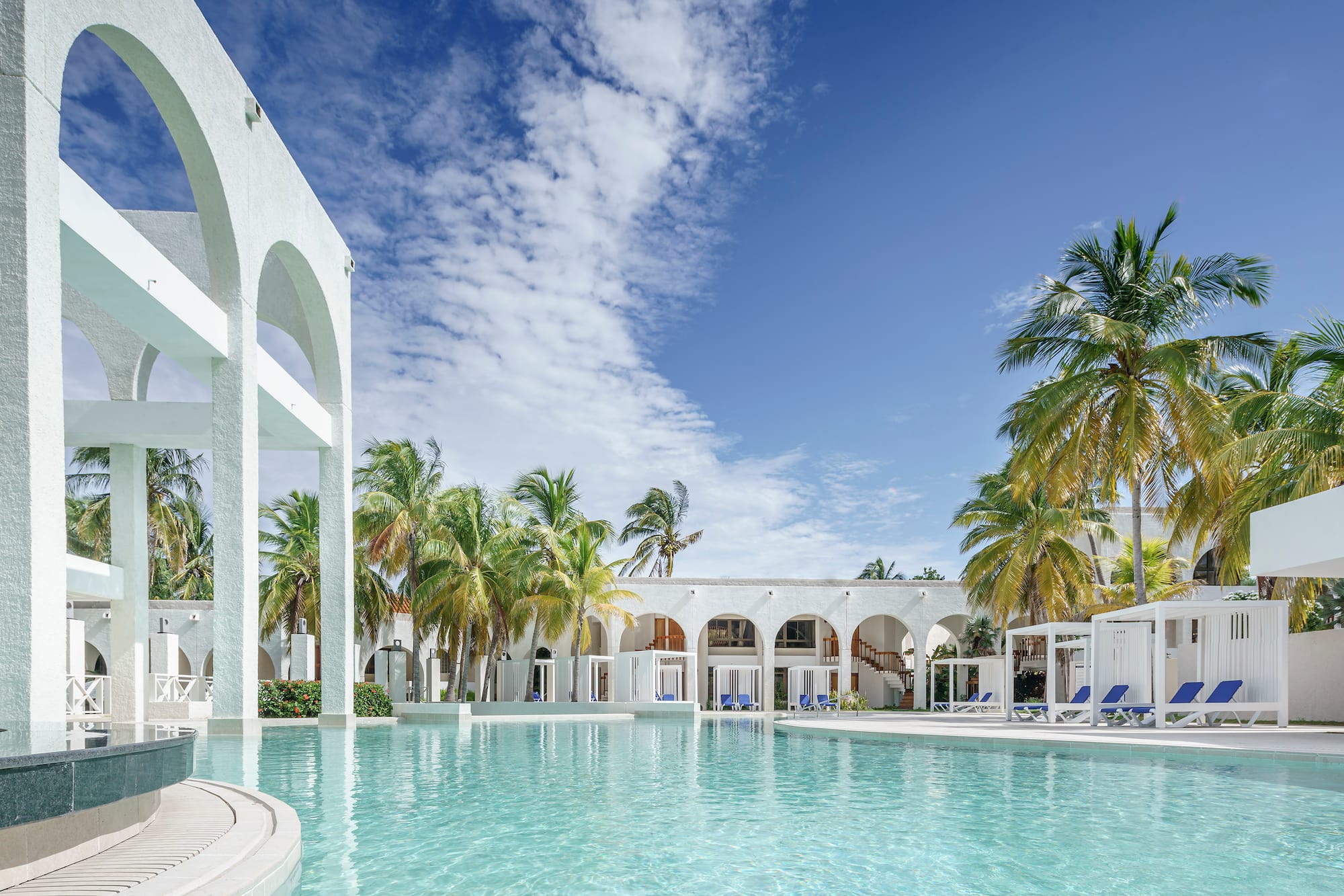 a pool with palm trees and arches