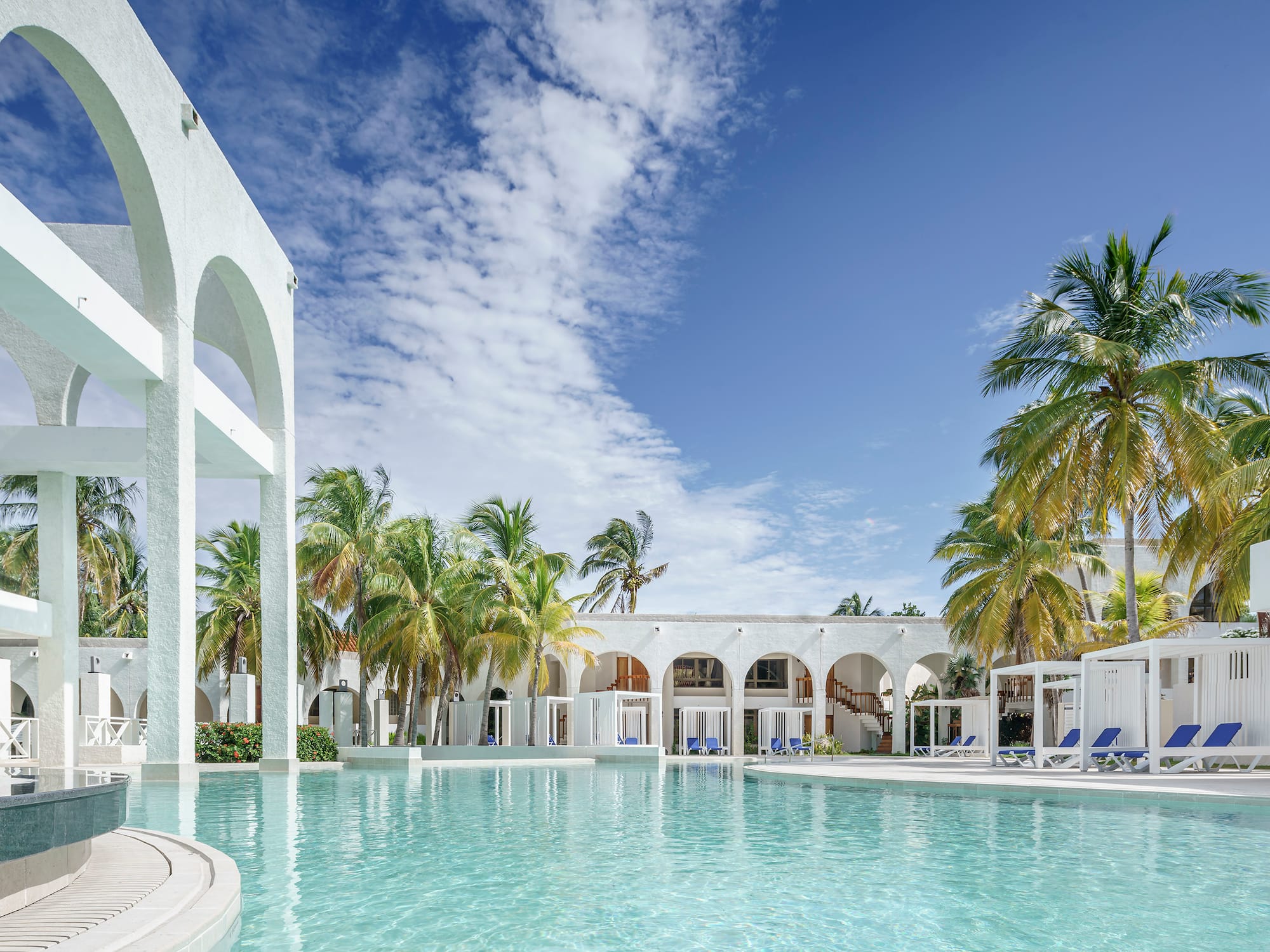 a pool with palm trees and arches