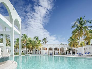 a pool with palm trees and arches