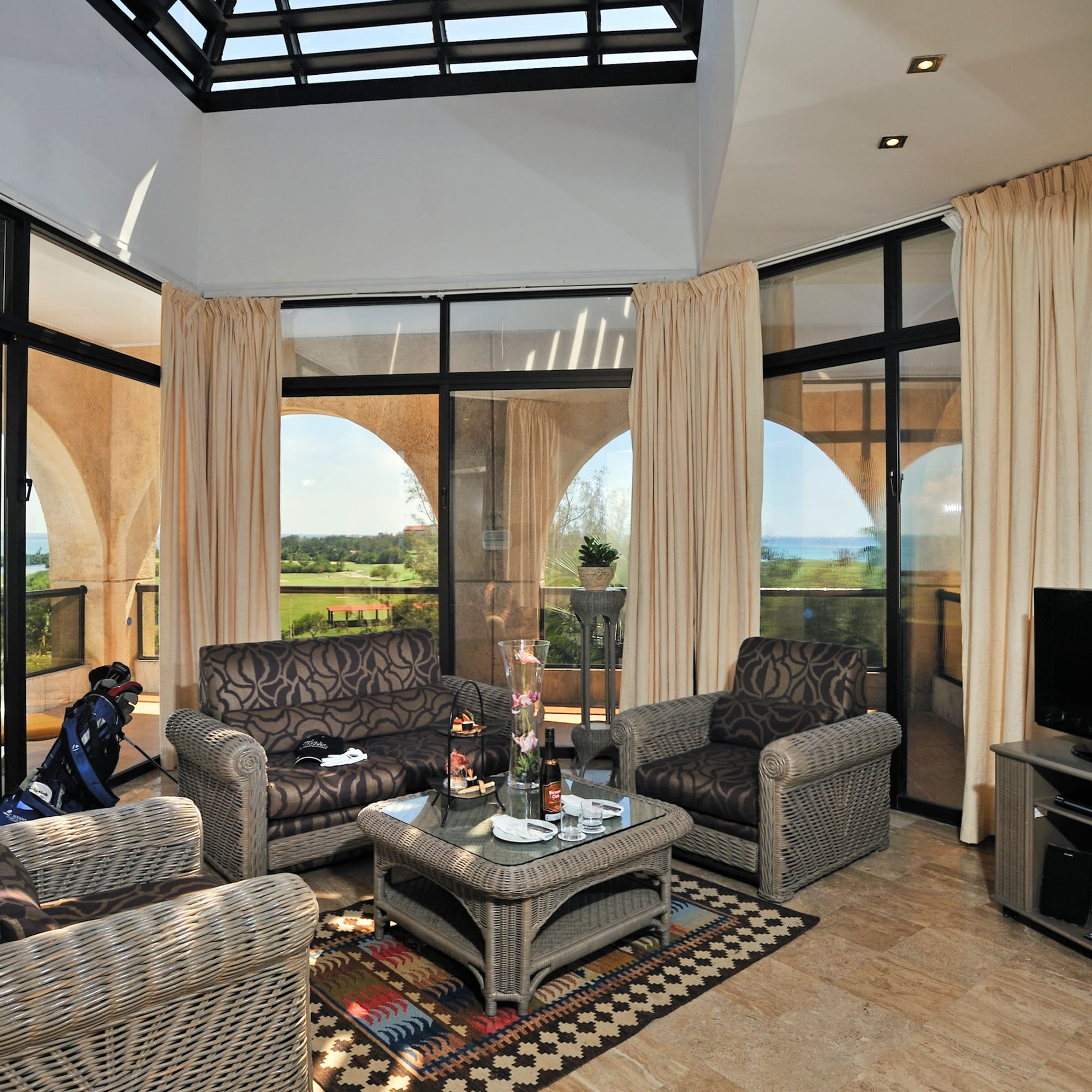 a living room with a glass roof and a television