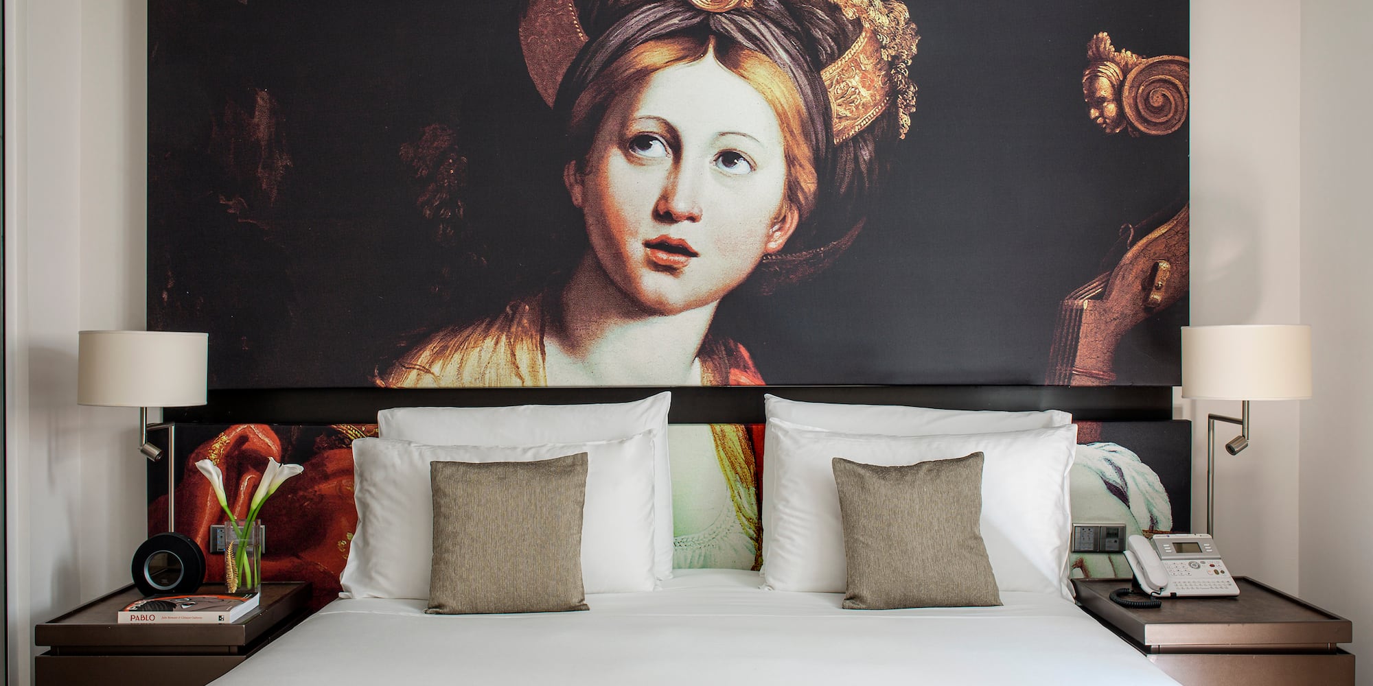 a bed with a painting on the wall