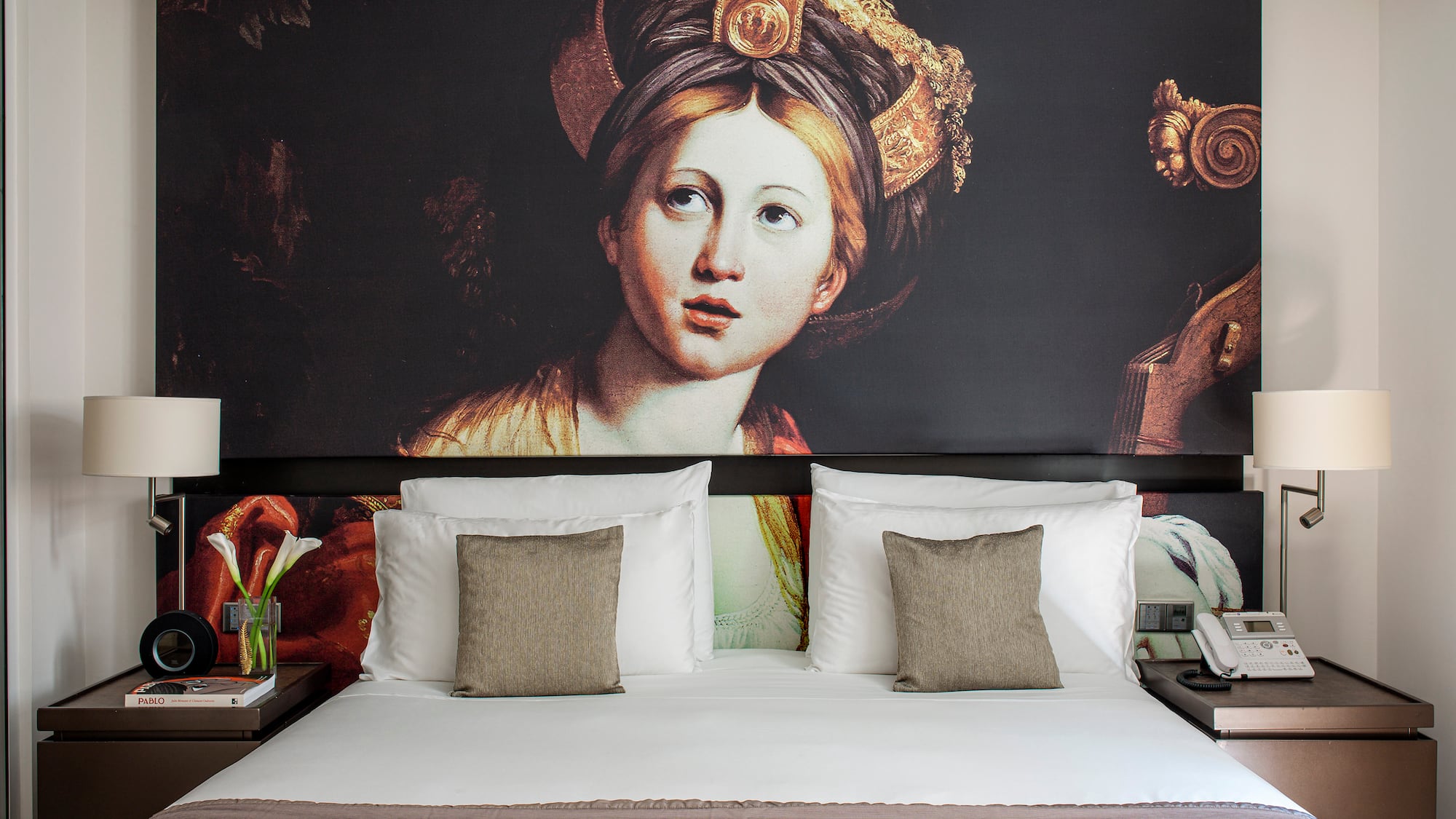a bed with a painting on the wall