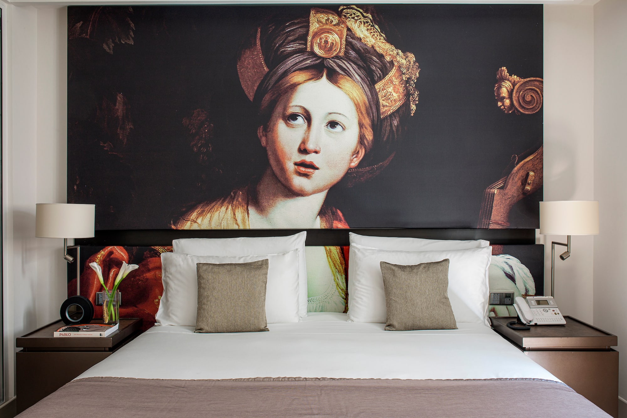 a bed with a painting on the wall