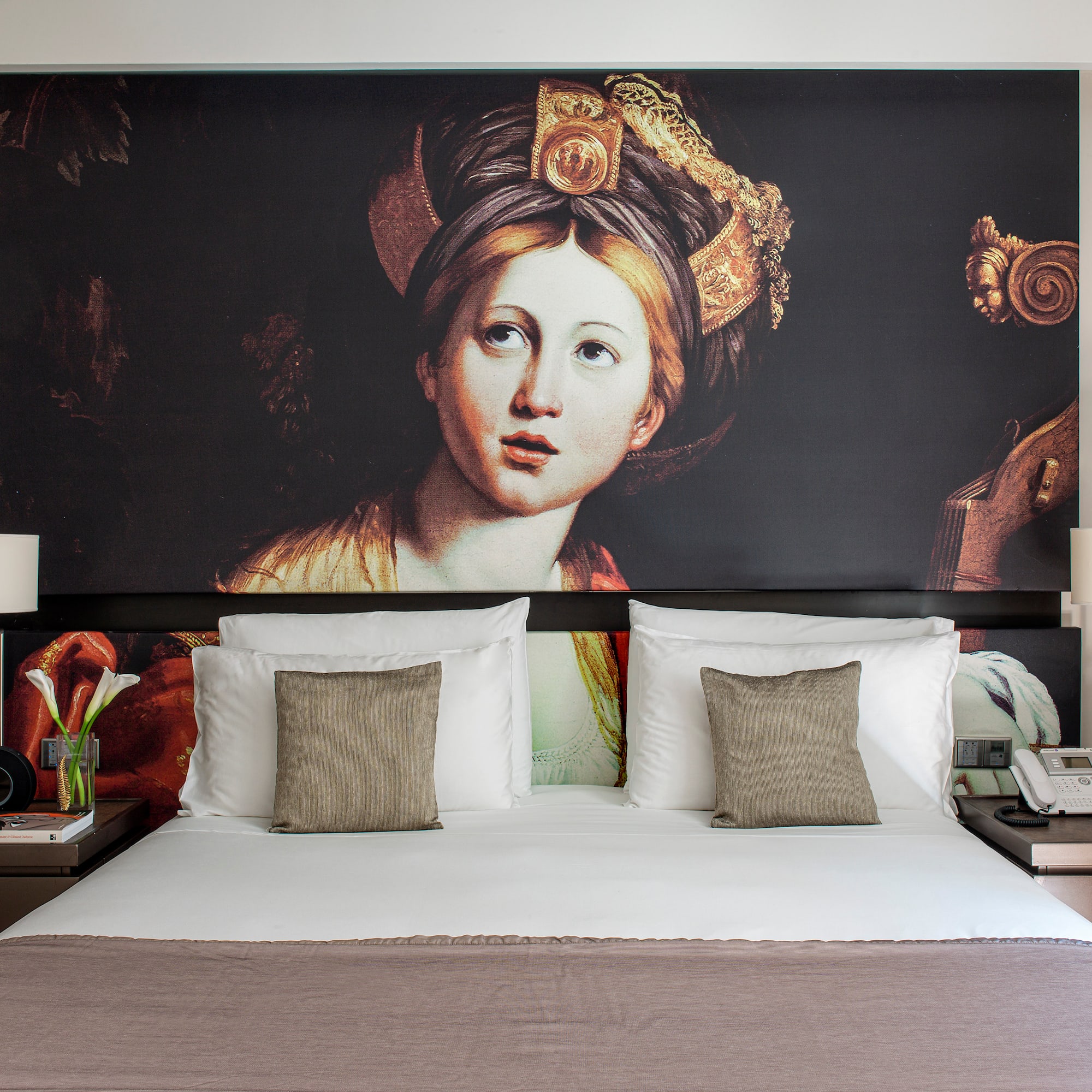 a bed with a painting on the wall