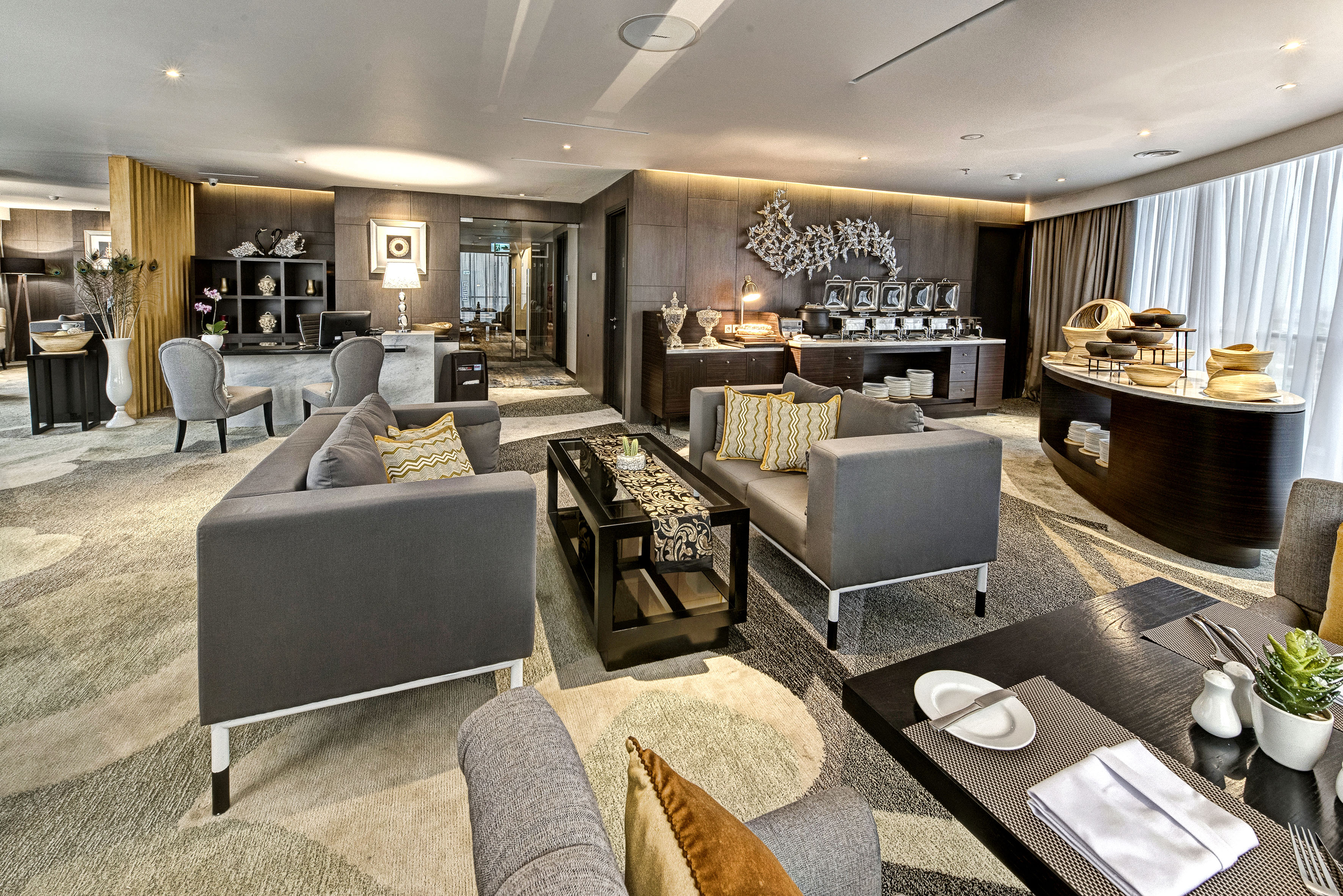 Upscale hotel club lounge with buffet, reception area, and modern seating.