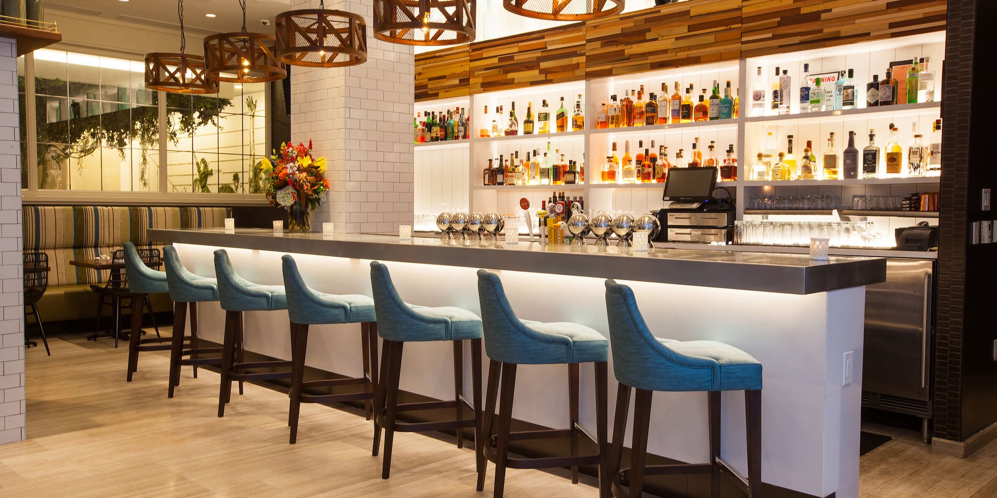 a bar with a row of stools and bottles